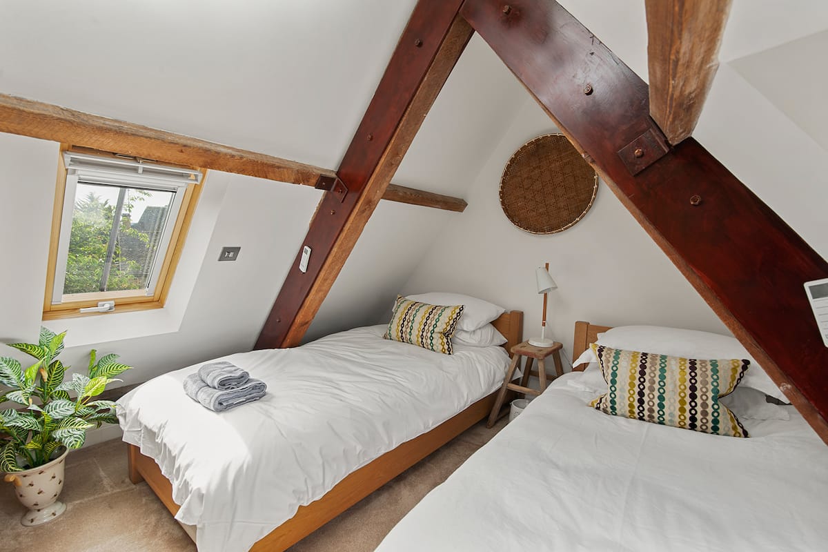 Twin bedroom beneath roof beams